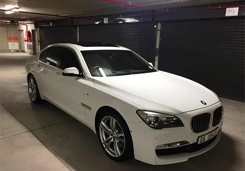 White BMW 7 Series sedan parked in an underground garage