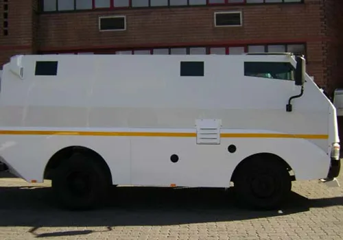 Side view of a white armoured transit truck with a yellow stripe